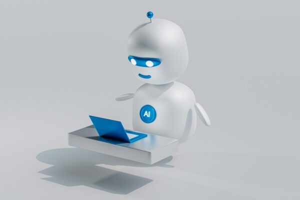 a white robot with blue eyes and a laptop